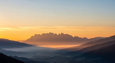 Fototapeta premium Majestic mountain range shrouded in mist at sunrise, a serene landscape.