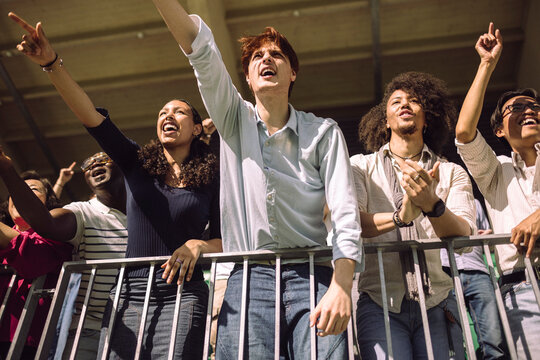 Low angle view of multiracial male and female sports enthusiast cheering from stadium stand