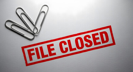 Red rectangular stamp displaying the text FILE CLOSED next to several shiny metallic paper clips
