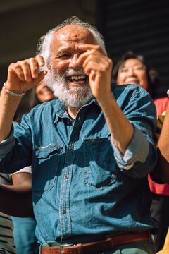 Carefree senior man dancing while enjoying at sports stadium stand
