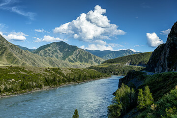 A river in the mountains on a clear sunny day. Road next to the water