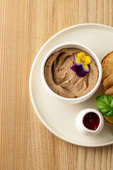 A creamy bowl of hummus garnished with olive oil, herbs, and spices, served as a flavorful Mediterranean dip.