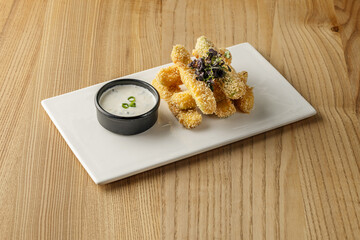 Crispy breaded chicken tenders served with a dipping sauce, creating a delicious and appetizing meal presentation.