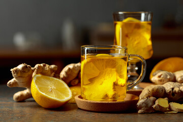 Obraz premium Ginger tea with lemon on a kitchen table.