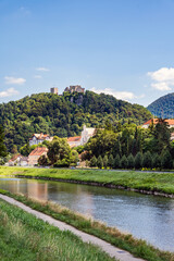 Waterfront of the Savinja river (Savinjsko nabrezje) with Celje Castle on the hilltop and a green urban landscape in Celje, eastern Slovenia.
