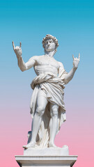 Classic statue of a figure striking a rock and roll pose against a colorful sky at sunset