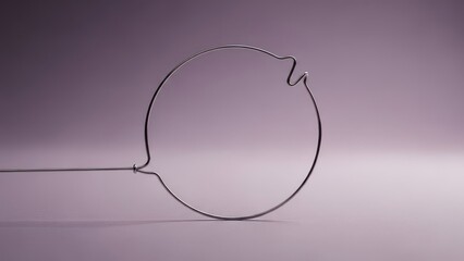 Close up of a single wire loop with a handle against a soft gradient background