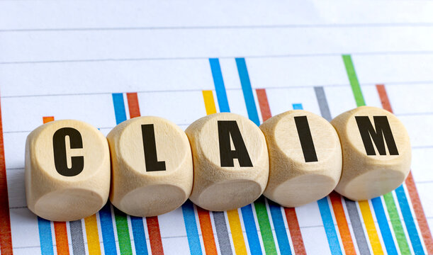 CLAIM word on wooden rounded blocks placed over colorful financial bar chart
