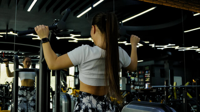 Woman is doing shoulder presses with dumbbells - Powered by Adobe
