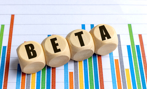 BETA word on wooden round blocks over multicolored financial chart with vertical bars