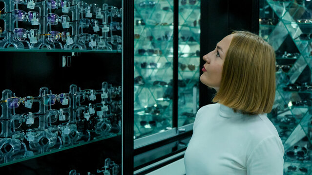 The woman is observing the optical properties of the objects