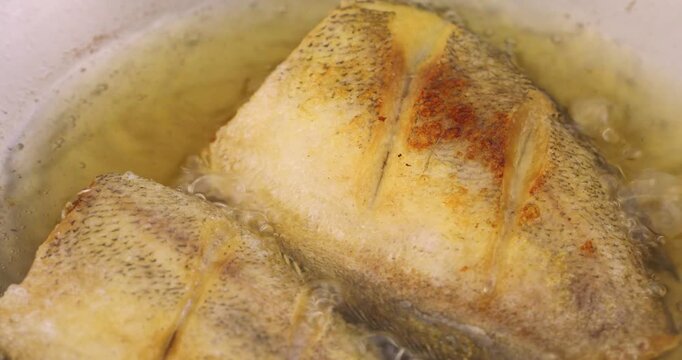 Deep-frying Thai-style snakeskin gourami in hot oil, close-up cooking footage.