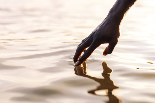 Hand of man touching water of lake