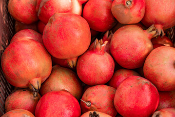red ripe pomegranates fruit in a container. bright background, pomegranates close up