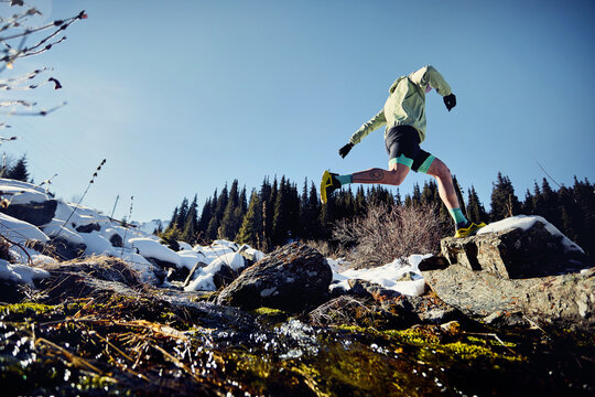 Man running trough the river in the winter mountains