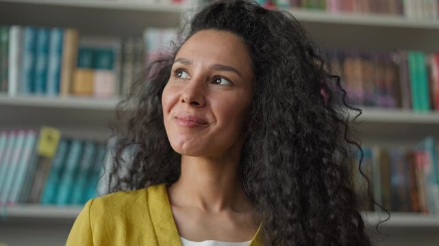 Glad Arabian Hispanic woman female girl reading book literature in library interesting hobby read think imagine inspiration contemplation delight pleasure novel plot student education bookstore story