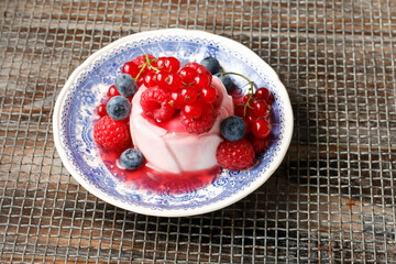 Panna cotta, italian dessert decorated with fresh red fruits.