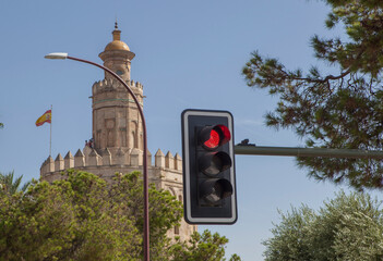 Red traffic light with the Torre del Oro of Seville