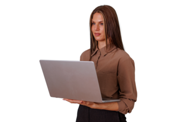 Young businesswoman holding a portable computer, standing with determined expression, focusing on work, digital native