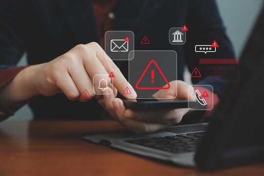 Cybersecurity warning on mobile phone showing alert messages and phishing scams targeting email, bank, and personal data. online safety and data protection while using smartphone and laptop at home.