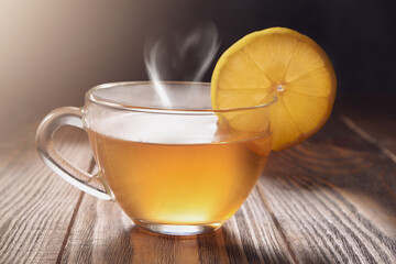 Transparent tea cup with lemon and heart-shaped steam on a textured table