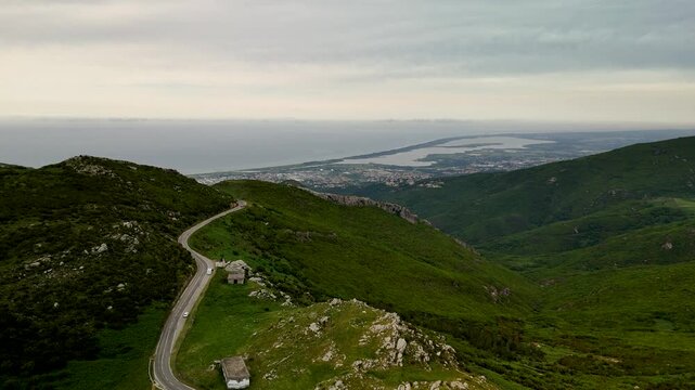 Cinematic Aerial Flight Over Lush Green Corsican Mountains Towards Vast Biguglia Lagoon and Mediterranean Coast near Bastia on a Cloudy Day