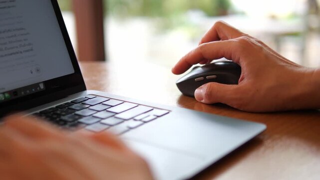 Hand Using Wireless Mouse While Working on Laptop &ndash; Remote Work and Productivity Concept