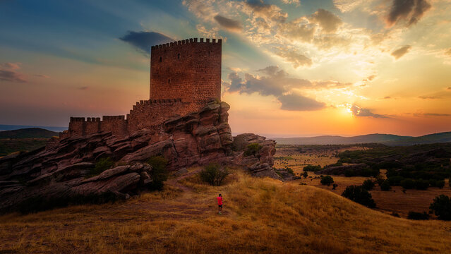 The figure wearing a red shirt at Zafra Castle is a 12th-century castle located in the Spanish municipality of Campillo de Due&ntilde;as, in the province of Guadalajara. It is a prime example of a rock castl