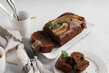 Homemade banana bread with dark chocolate close-up on table. Horizontal top view from above