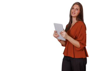 Young businesswoman with an orange shirt standing, holding a tablet, engaging with technology for professional tasks. Transparent background