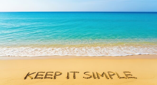 Keep it simple text written in beach sand near the turquoise ocean water