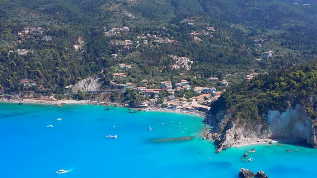 Blue water and beach by vacation village in Greece. Aerial drone view of wonderful vacation defiltration landscape. Greek island Lefkada Ionian sea west coast