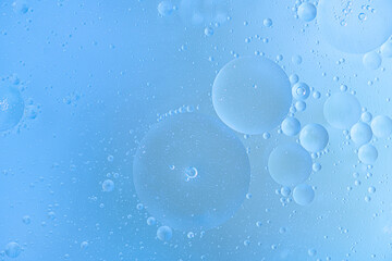 abstract background of oil bubbles in water close up in blue tones
