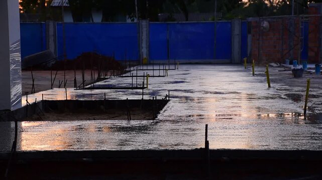 Construction workers pour concrete floors, Concrete pouring during commercial floor construction faceless workers coordinating defocused, Construction workers pouring concrete over metal grid with cem