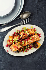 Two grilled salmon steaks on a wooden table.