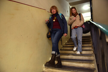 two women walking down stairs in an old building