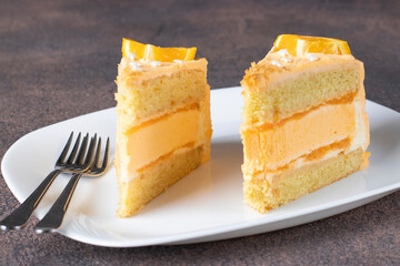 Two pieces of vanilla sponge cake with orange cream and mousse