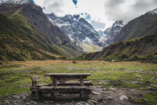 Wooden table and benches against the backdrop of the snow-capped Caucasus Mountains