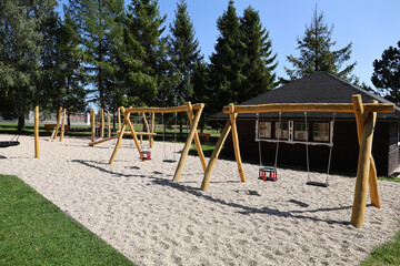 Children's playground with wooden swings.