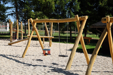 Children's playground with wooden swings.