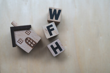 Wooden cubes with letters WFH and wood home. Business concept image, commonly used to represent work from home.