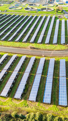 Side drone view of a solar farm in portrait orientation, clean renewable energy powered by sunlight
