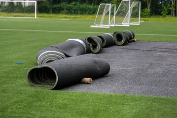 Konzept Sanierung Kunstrasen: Blick auf einen Fußballplatz mit Kunstrasen dessen Untergrund und...
