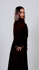  A woman posing sideways in a long black outfit, expressing stylish minimalism