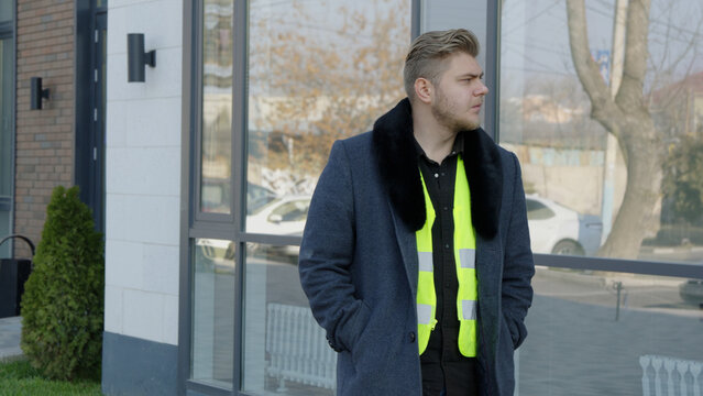  A worker in a reflective vest standing outdoors near a construction site