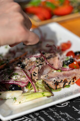 Close up of sliced tagliata beef steak served on a plate in fine dining restaurant
