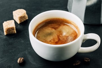 A Steaming Cup of Coffee with Sugar Cubes and Coffee Beans on a Dark Background, Capturing the Essence of a Morning Ritual