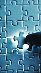 Hand Placing Final Glowing Puzzle Piece