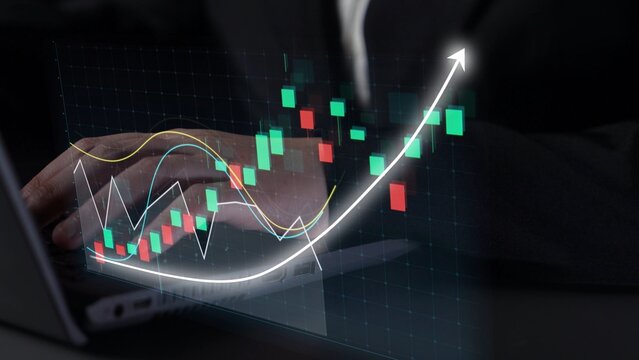 A close-up of a professional hand interacting with a laptop displaying a stock market graph, illustrating an upward trend in finance and investment analysis. Copula