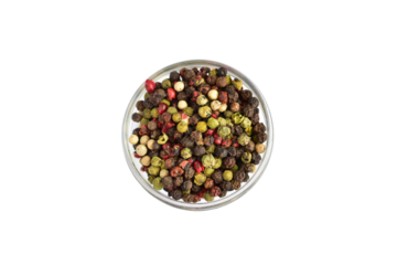 Peppercorns of different colors lie in a round vase. View from above.